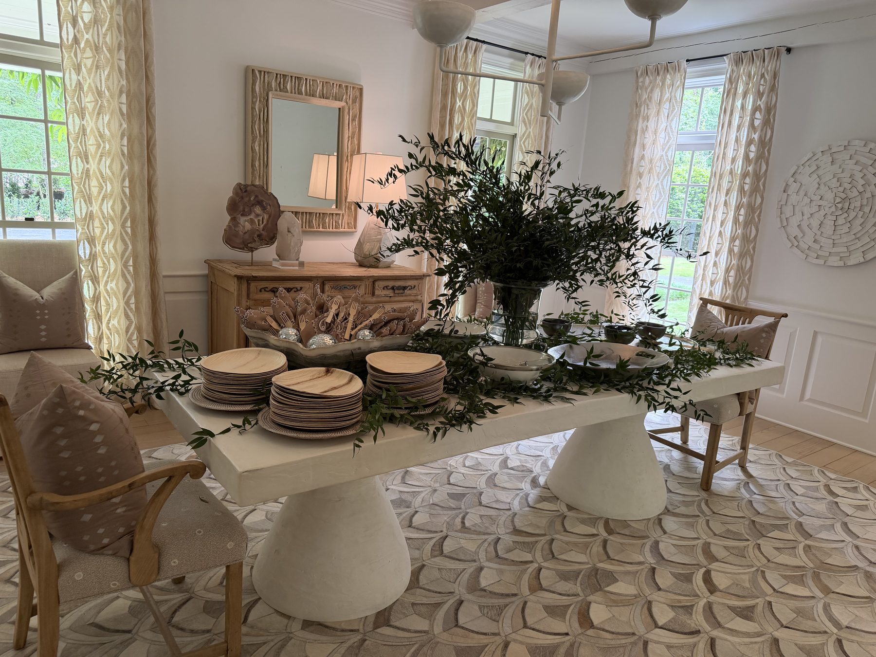 Dining room with sculptural plaster table and woven hide rug